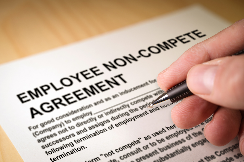 Man,Signing,An,Employee,Non Compete,Agreement