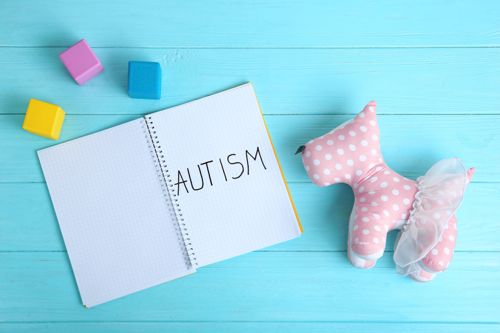 Notebook,With,Word,Autism,And,Toy,Dog,On,Color,Background,