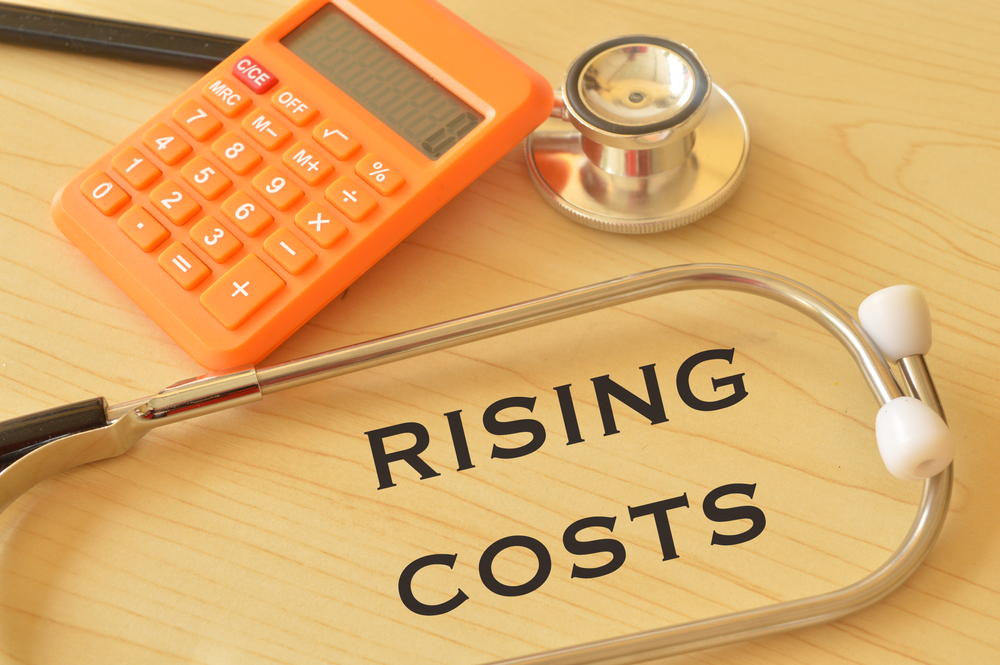 Calculator,,Stethoscope,On,The,Table,With,Phrase,Rising,Costs.