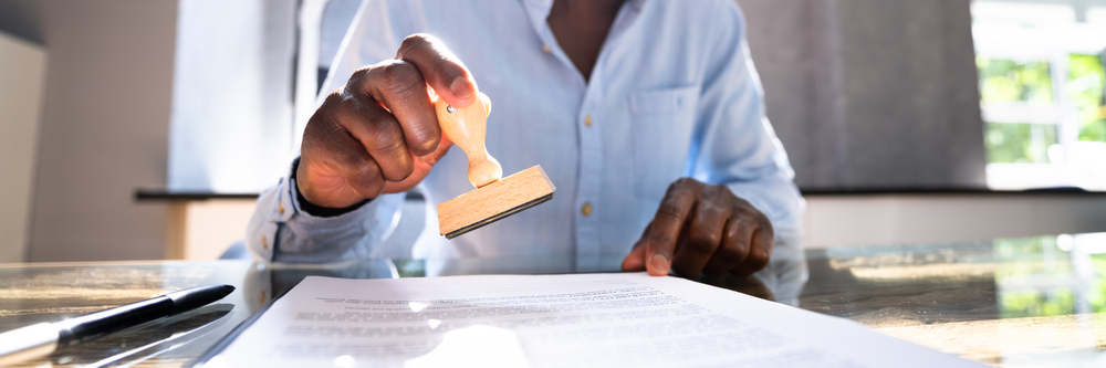 African,American,Black,Man,Using,Notary,Stamp,On,Official,Paper