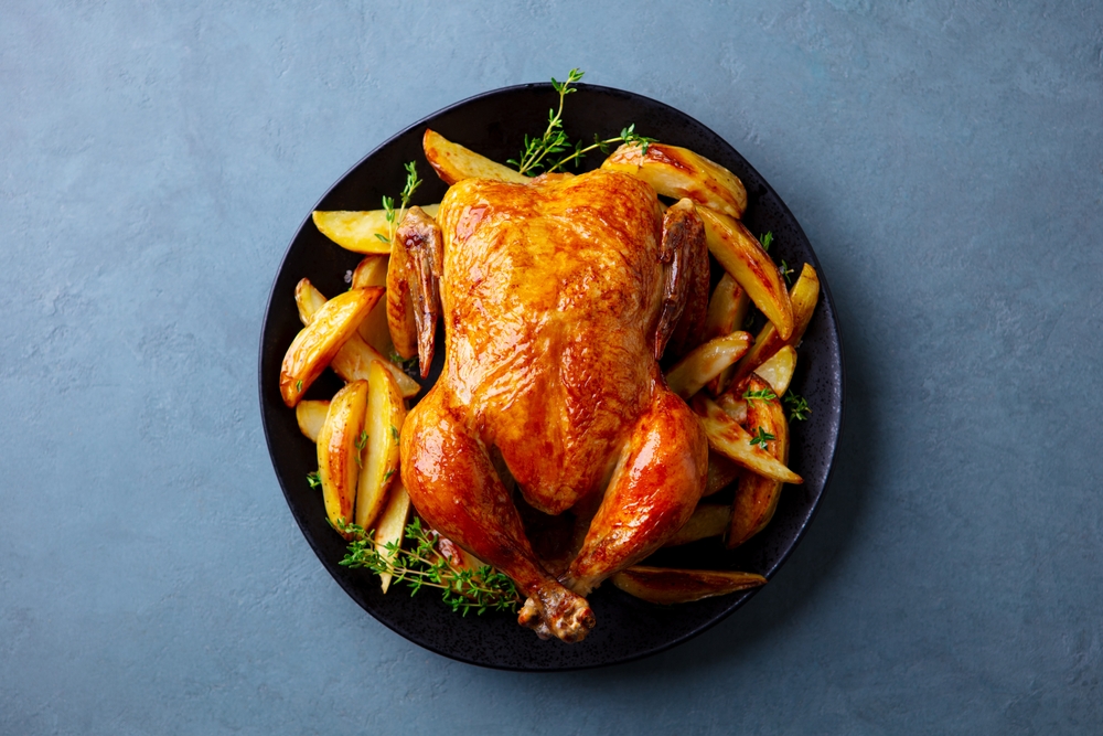 Roasted,Chicken,With,Potatoes,On,Dark,Plate.,Grey,Background.,Close