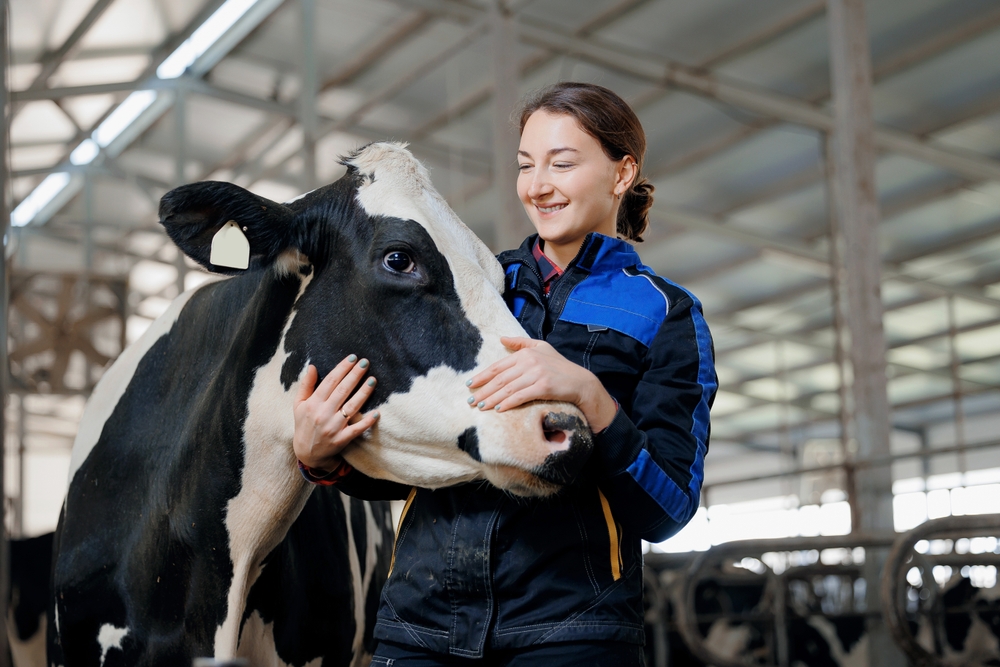 Happy,Young,Woman,Farm,Worker,Hugging,Cow,As,Sign,Of