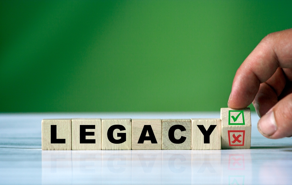 A,Hand,Adjusting,Wooden,Blocks,To,Form,The,Word,Legacy